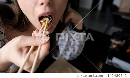 Close-up of Caucasian woman eating pan-Asian cuisine Close-up of Caucasian woman eating pan-Asian cuisine 142489541