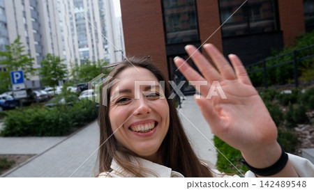 Close-up portrait of attractive young Caucasian girl smiling and looking at camera, taking selfie video. Cute woman broadcasting video with smartphone, waving at webcam Close-up portrait of attractive young Caucasian girl smiling and looking at camera, taking selfie video. Cute woman broadcasting video with smartphone, waving at webcam 142489548