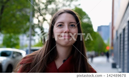 Portrait photo of happy young smiling woman in burgundy coat during city walk outdoors Portrait photo of happy young smiling woman in burgundy coat during city walk outdoors 142489678