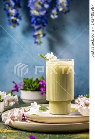 Cold matcha latte decorated with flowers on a table Cold matcha latte decorated with flowers on a table 142489967