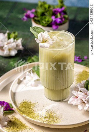Iced matcha latte decorated with mint and flowers on table Iced matcha latte decorated with mint and flowers on table 142489968