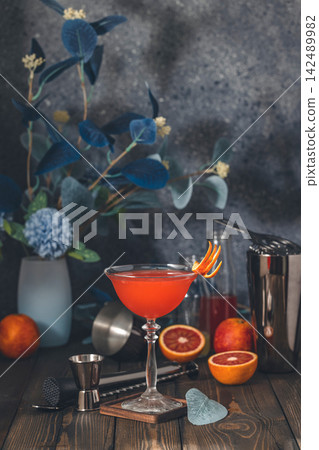 Blood orange cocktail in coupe glass on bar counter Blood orange cocktail in coupe glass on bar counter 142489982