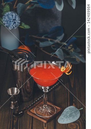 Refreshing red cocktail with citrus peel garnish Refreshing red cocktail with citrus peel garnish 142489984