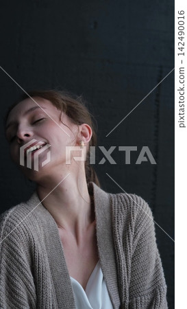 Portrait of a beautiful young girl on a dark studio background. Beautiful natural woman posing for the camera Portrait of a beautiful young girl on a dark studio background. Beautiful natural woman posing for the camera 142490016