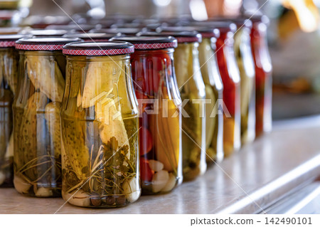 Preserving the harvest: rows of glass jars brimming with pickled vegetables Preserving the harvest: rows of glass jars brimming with pickled vegetables 142490101