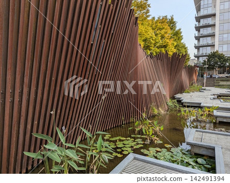 Portland, Oregon, USA - September 6, 2024: Artwall and pond at Tanner Springs Park Portland, Oregon, USA - September 6, 2024: Artwall and pond at Tanner Springs Park 142491394