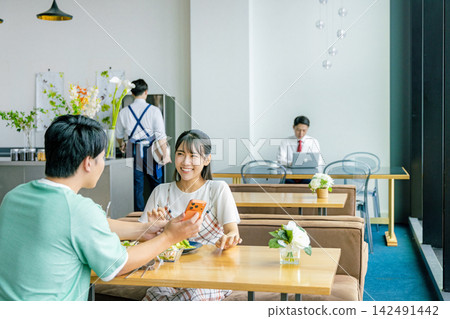 一對年輕夫婦在咖啡館看智能手機 142491442