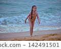 Little girl playing with yellow shovel on tropical beach Hikkaduwa Sri Lanka 142491501