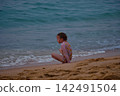 Little girl playing with yellow shovel on tropical beach Hikkaduwa Sri Lanka 142491504
