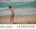 Little girl playing with yellow shovel on tropical beach Hikkaduwa Sri Lanka 142491506