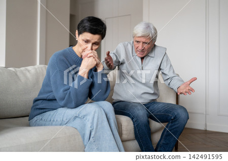 Upset depressed senior woman under verbal abuse during quarrel with frustrated annoyed husband. Upset depressed senior woman under verbal abuse during quarrel with frustrated annoyed husband. 142491595