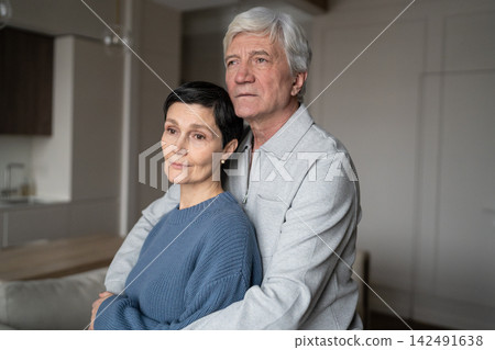 Thoughtful senior man hugging wife with love. Elderly couple hug, marital care, calm aging together Thoughtful senior man hugging wife with love. Elderly couple hug, marital care, calm aging together 142491638