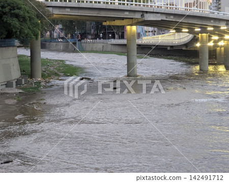 Swollen Suquia River Flowing Beneath an Urban Bridge Swollen Suquia River Flowing Beneath an Urban Bridge 142491712