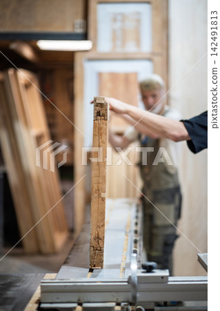 Professional woodworking studio working process, skillful carpenters placing vintage wooden door at workbench in woodshop, workflow in private repair and restoration workshop. Professional woodworking studio working process, skillful carpenters placing vintage wooden door at workbench in woodshop, workflow in private repair and restoration workshop. 142491813