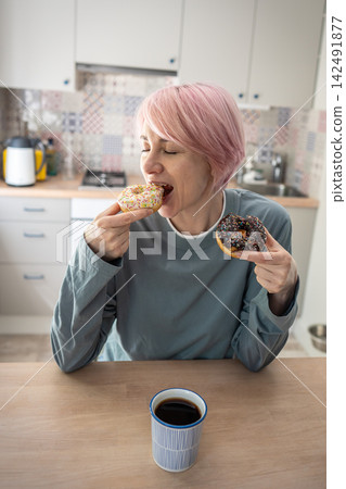 Period and pms syndrome leading to uncontrolled appetite for sweet food, mature woman eats doughnuts Period and pms syndrome leading to uncontrolled appetite for sweet food, mature woman eats doughnuts 142491877