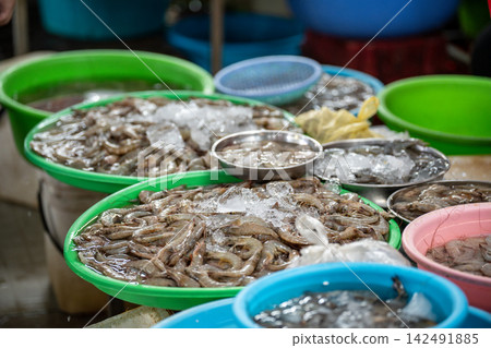 Morning catch of shrimps at seafood street market market, basins filled with shrimps covered in ice. 142491885