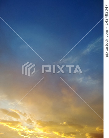 vertical shot of sunset sky showing bright golden clouds below and deep blue tones above vertical shot of sunset sky showing bright golden clouds below and deep blue tones above 142492047