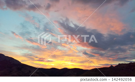 vibrant sunset sky over dark hills vibrant sunset sky over dark hills 142492056