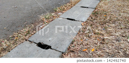 Concrete Drainage Slabs Bordering an Asphalt Road Concrete Drainage Slabs Bordering an Asphalt Road 142492740