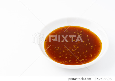 Barbecue sauce in a small dish against a white background. 142492920