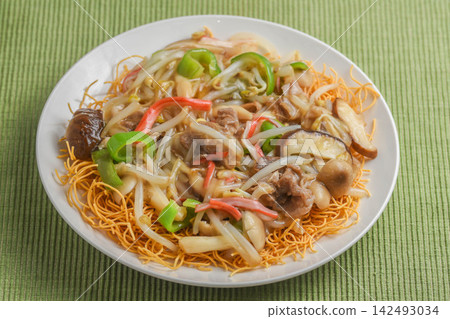 Deep-fried noodles with plenty of vegetables in a thick sauce. 142493034