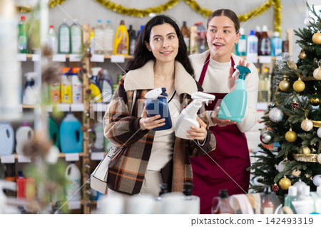 Girl consultant helps female buyer choose tile cleaner spray Girl consultant helps female buyer choose tile cleaner spray 142493319