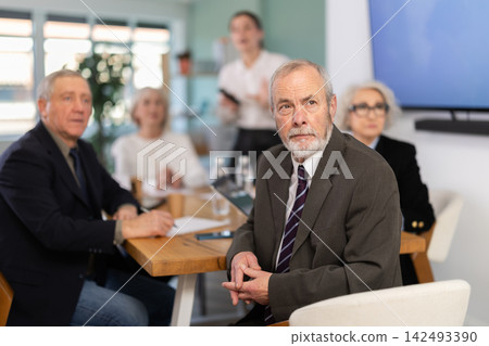 Businessman watching presentation while gathering in meeting room Businessman watching presentation while gathering in meeting room 142493390