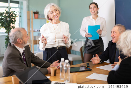 Senior female speaker shares happy news, makes participants laugh Senior female speaker shares happy news, makes participants laugh 142493419