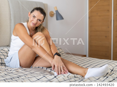 Woman in lingerie posing lying on bed at home Woman in lingerie posing lying on bed at home 142493420