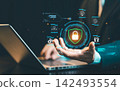 Businessman holding glowing shield padlock icon on virtual screen with laptop background, cybersecurity, data protection, and privacy network concept. 142493554