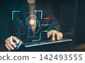 User operating computer keyboard with glowing AI head profile hologram and data stream overlay, artificial intelligence and machine learning concept. 142493555