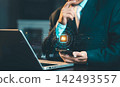 Businessman holding smartphone with glowing AI microchip hologram and business icons overlay, artificial intelligence and smart technology concept. 142493557