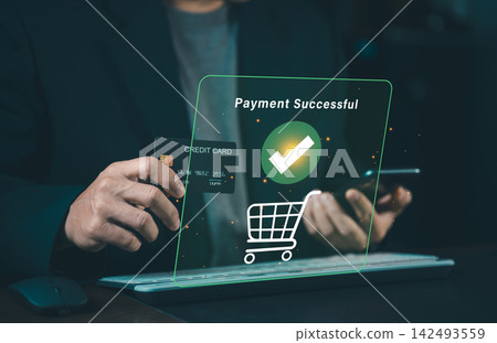 Close up of businessman holding credit card and smartphone with green payment successful icon hologram, online checkout and e-commerce concept. 142493559