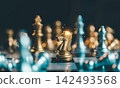 Close up of golden knight chess piece standing on chessboard with blurred background, strategic move, business tactic and leadership concept. 142493568