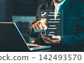 Businessman checking digital check mark boxes on hologram survey checklist on smartphone with laptop, quality control and survey concept. 142493570