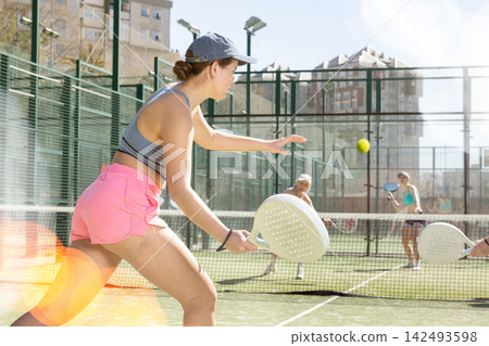 Young woman playing Padel Tennis in pairs in tennis court Young woman playing Padel Tennis in pairs in tennis court 142493598