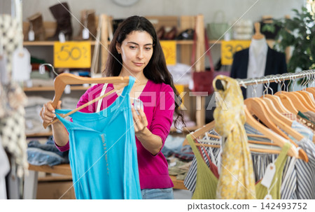 Armenian woman chooses a summer dress on sale Armenian woman chooses a summer dress on sale 142493752