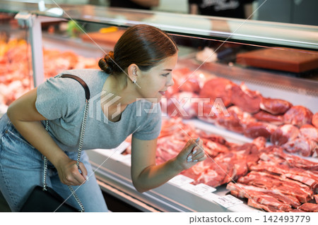 Female customer points with finger and orders beef brisket and sirloin Female customer points with finger and orders beef brisket and sirloin 142493779