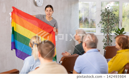 Young female tutor talking to group of seniors about LGBT movements Young female tutor talking to group of seniors about LGBT movements 142493984