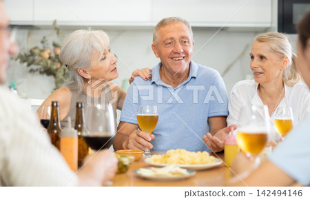 Elderly people drinking and chatting at table 142494146