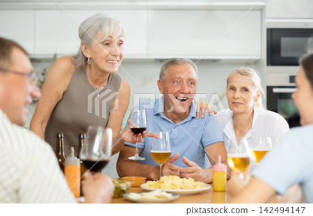 Elderly people drinking and chatting at table Elderly people drinking and chatting at table 142494147