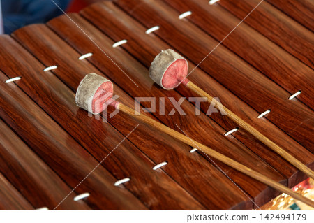 Traditional Thai xylophone mallets resting polished wooden bars highlighting musical heritage craftsmanship rhythm cultural performance Traditional Thai xylophone mallets resting polished wooden bars highlighting musical heritage craftsmanship rhythm cultural performance 142494179