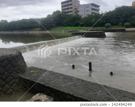 一座橫跨河流的橋樑;一條湍急的河流。 一座橫跨河流的橋樑;一條湍急的河流。 142494249