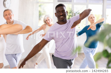 Mature men and women practicing Hip-hop dance in training hall Mature men and women practicing Hip-hop dance in training hall 142494265