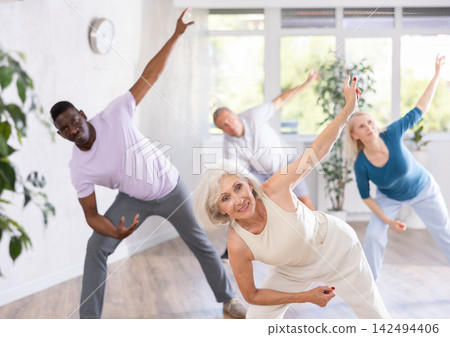 Active mature men and women practicing Jazz-funk dance in training hall Active mature men and women practicing Jazz-funk dance in training hall 142494406