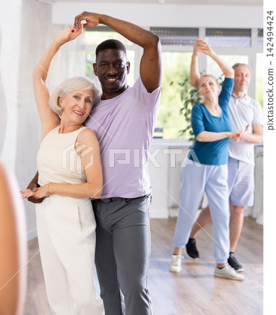 Group of multiethnic mature people dancing social dance Group of multiethnic mature people dancing social dance 142494424