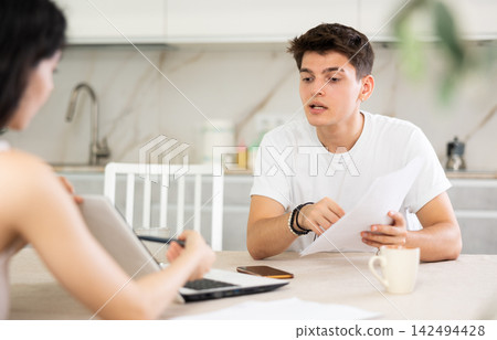 Young guy discussing deal with saleswoman in kitchen Young guy discussing deal with saleswoman in kitchen 142494428