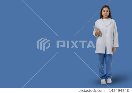 Medical worker stands holding a clipboard in a blue area Medical worker stands holding a clipboard in a blue area 142494848