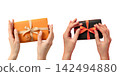 Two hands hold colorful gifts, showcasing festive wrapping and decorations, PNG 142494880