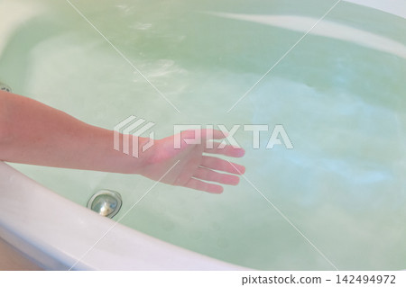 Stir the bathwater with your hands. Stir the bathwater with your hands. 142494972